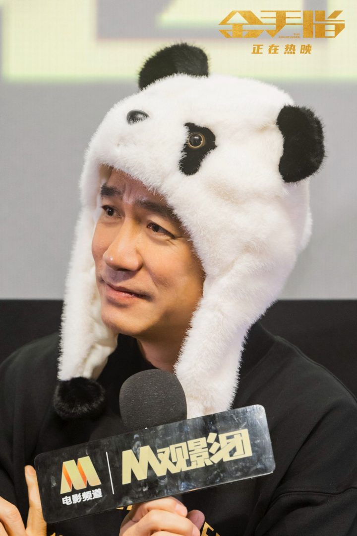 梁朝伟以《金手指》为主题，在成都路演中戴上熊猫头套学习四川话